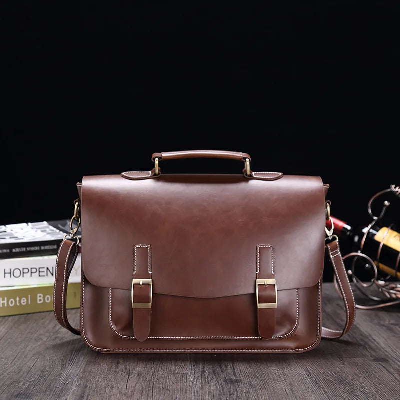 Borsa a tracolla in pelle marrone, design vintage, con fibbie dorate e manico superiore. Ideale per lavoro o scuola. Elegante e funzionale.