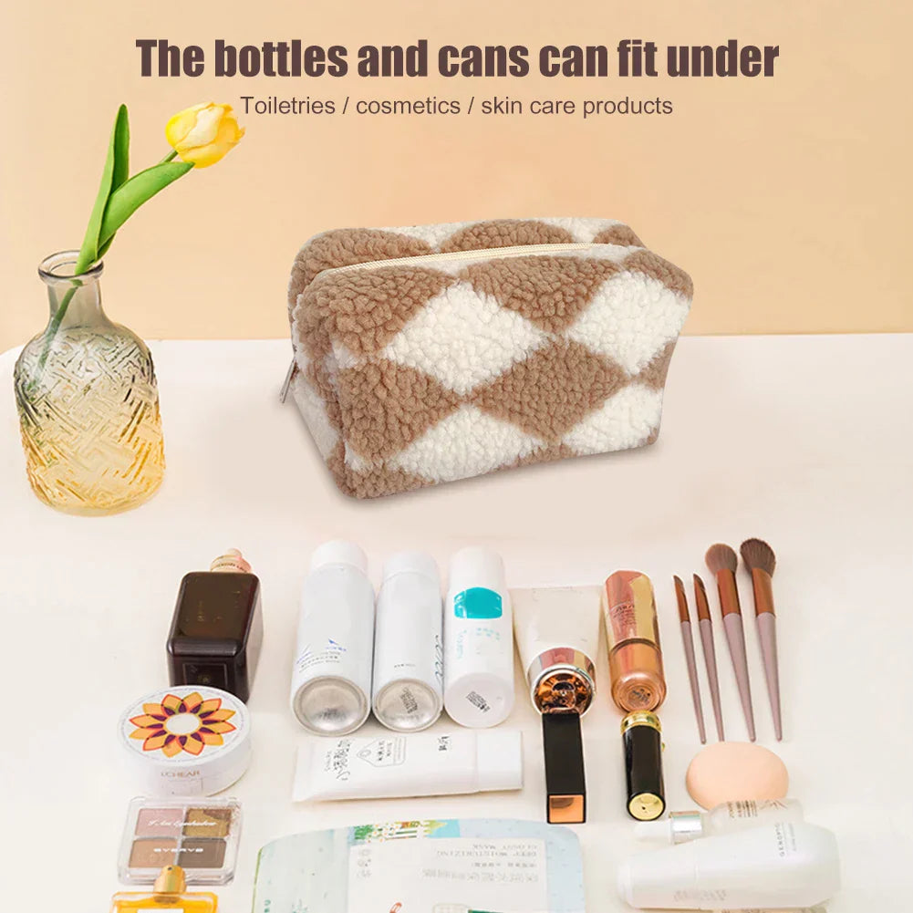 Borsa cosmetica in pelliccia sintetica a rombi beige e bianchi, con prodotti di bellezza e cura della pelle, pennelli trucco e flaconi su sfondo chiaro.