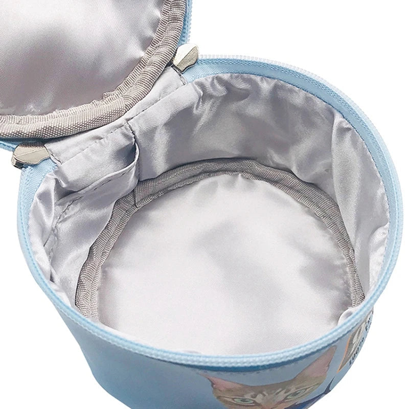 Astuccio rotondo azzurro con interno foderato in tessuto grigio, decorato con immagine di gatto. Ideale per cosmetici o accessori.