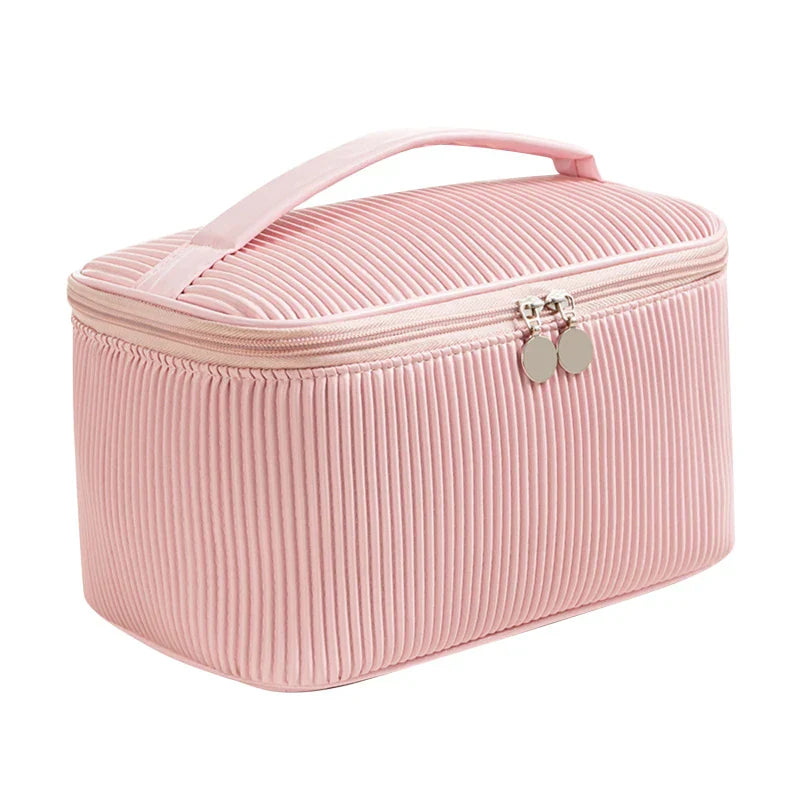 Astuccio cosmetico rosa in tessuto a coste con cerniera e manico, ideale per organizzare trucchi e accessori da viaggio.