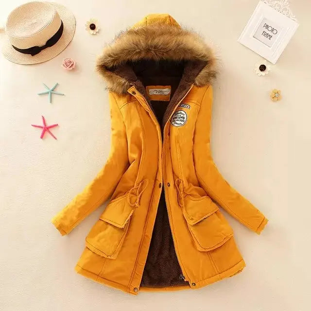 Giacca invernale donna gialla con cappuccio in pelliccia sintetica, tasche frontali e decorazioni. Elegante e calda, ideale per l'inverno.