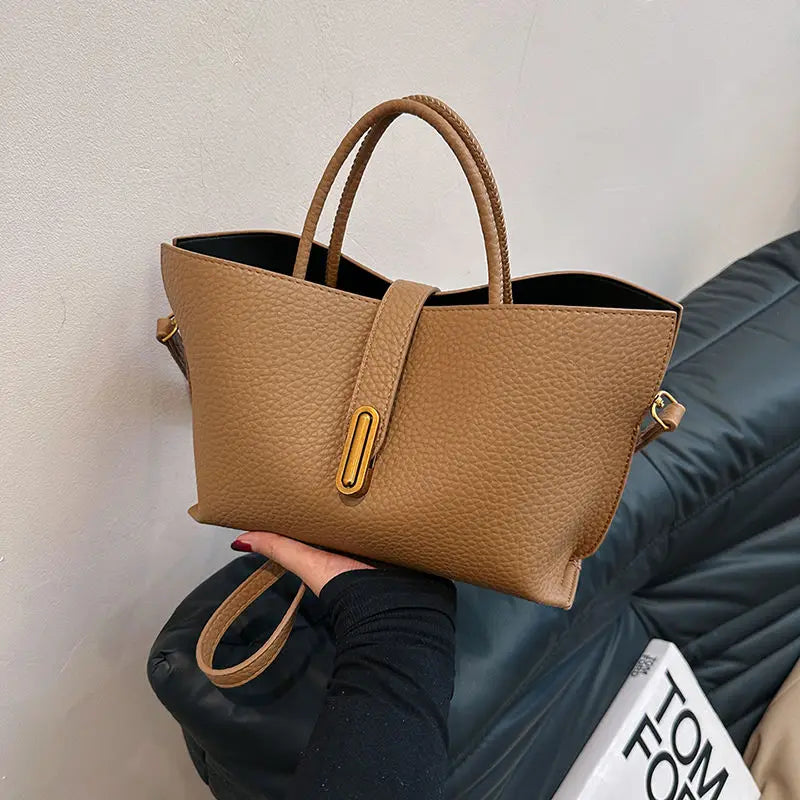 Borsa a mano in pelle marrone, design elegante, chiusura a bottone, manici doppi, ideale per moda donna, accessorio di tendenza.