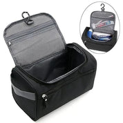 Borsa da toilette nera aperta con gancio, tasche a rete e scomparti per articoli da viaggio. Organizzatore compatto per cosmetici e accessori.