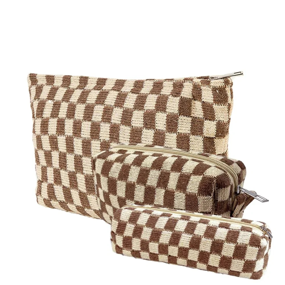 Set di tre astucci a scacchi marroni e beige con cerniera, ideali per cosmetici o cancelleria. Design elegante e pratico per l'organizzazione.