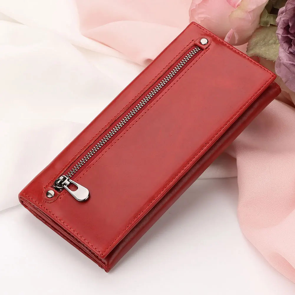 Portafoglio donna in pelle rossa con cerniera, elegante e moderno, su sfondo di tessuto rosa. Accessorio moda, regalo perfetto.