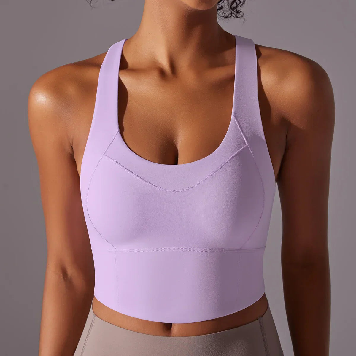 Top sportivo donna viola, design senza maniche, tessuto elasticizzato, ideale per yoga e fitness. Abbigliamento sportivo traspirante e confortevole.