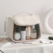 Borsa da toilette trasparente beige con manico, dimensioni 24x17,5x12,5 cm, contenente flaconi cosmetici. Ideale per viaggi e organizzazione bagno.