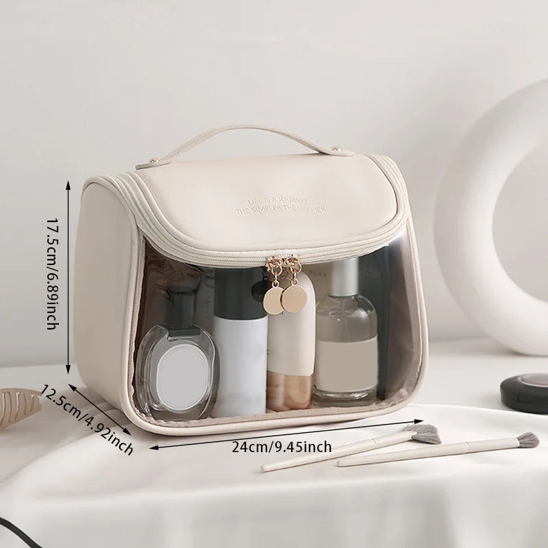 Borsa da toilette trasparente beige con manico, dimensioni 24x17,5x12,5 cm, contenente flaconi cosmetici. Ideale per viaggi e organizzazione bagno.