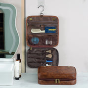 Beauty case da viaggio in pelle marrone appeso, con scomparti per pettine, spazzole e accessori. Ideale per organizzare prodotti cosmetici.