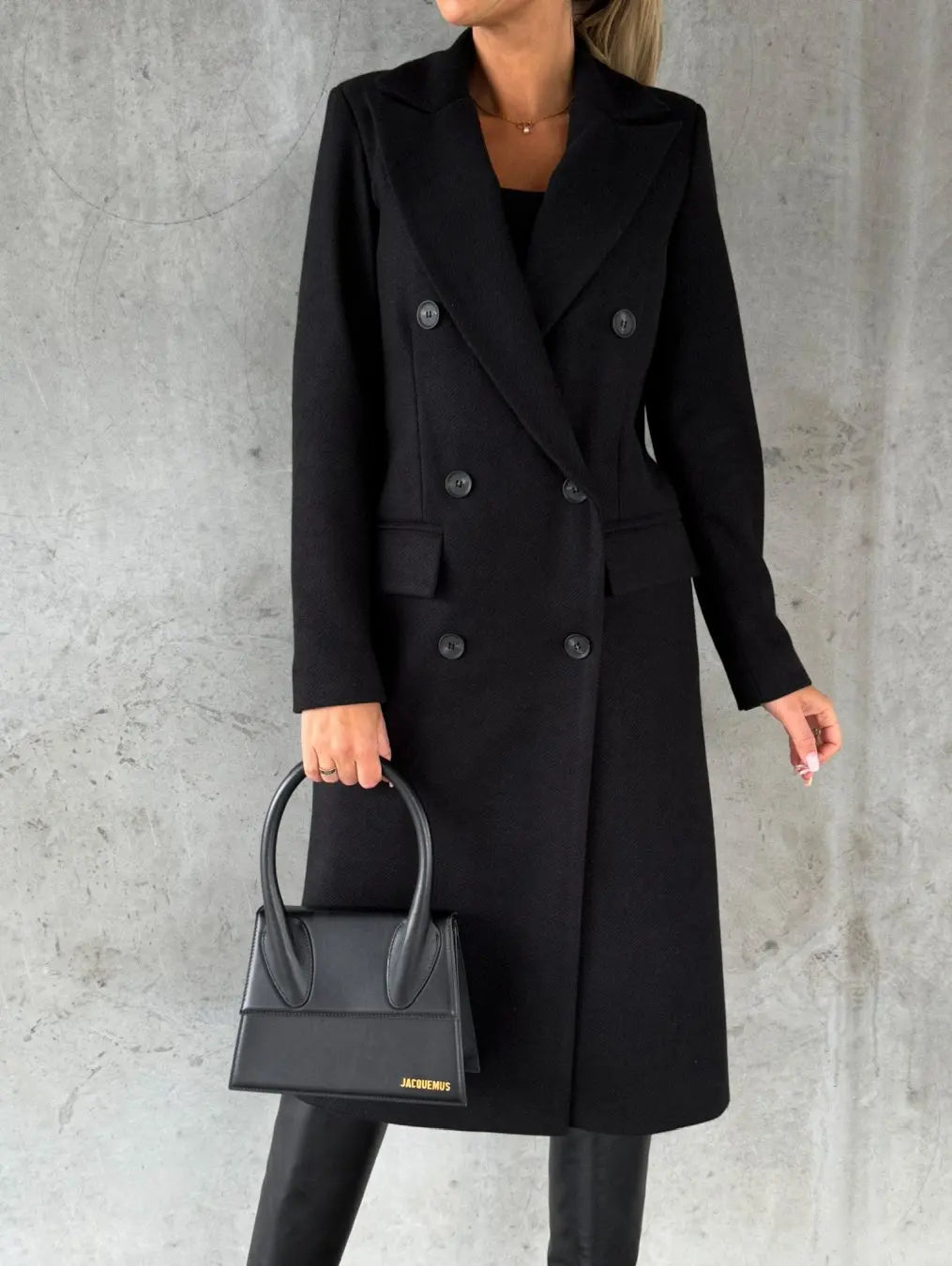 Cappotto nero elegante da donna, doppio petto, abbinato a borsa nera di lusso. Moda autunnale, stile sofisticato, abbigliamento femminile chic.