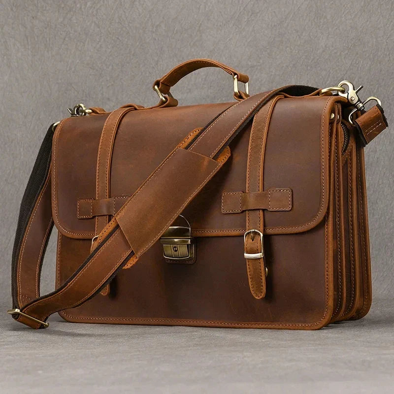 Elegante borsa ventiquattrore in pelle marrone con tracolla regolabile, chiusura a fibbia e manico superiore. Ideale per lavoro e viaggi d'affari.