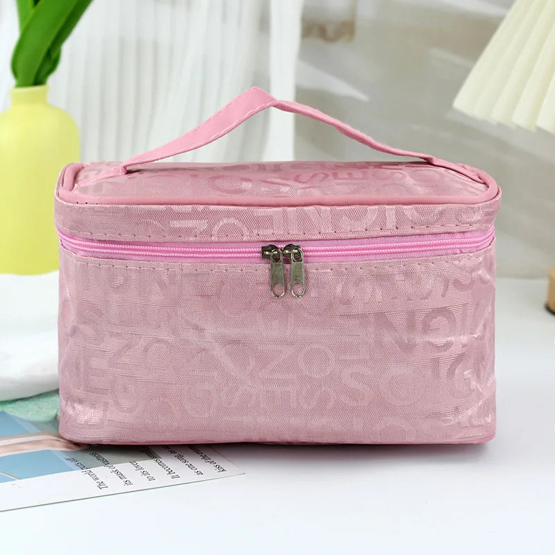 Borsa cosmetica rosa con cerniera, manico superiore, design elegante, ideale per organizzare trucchi e accessori da viaggio.