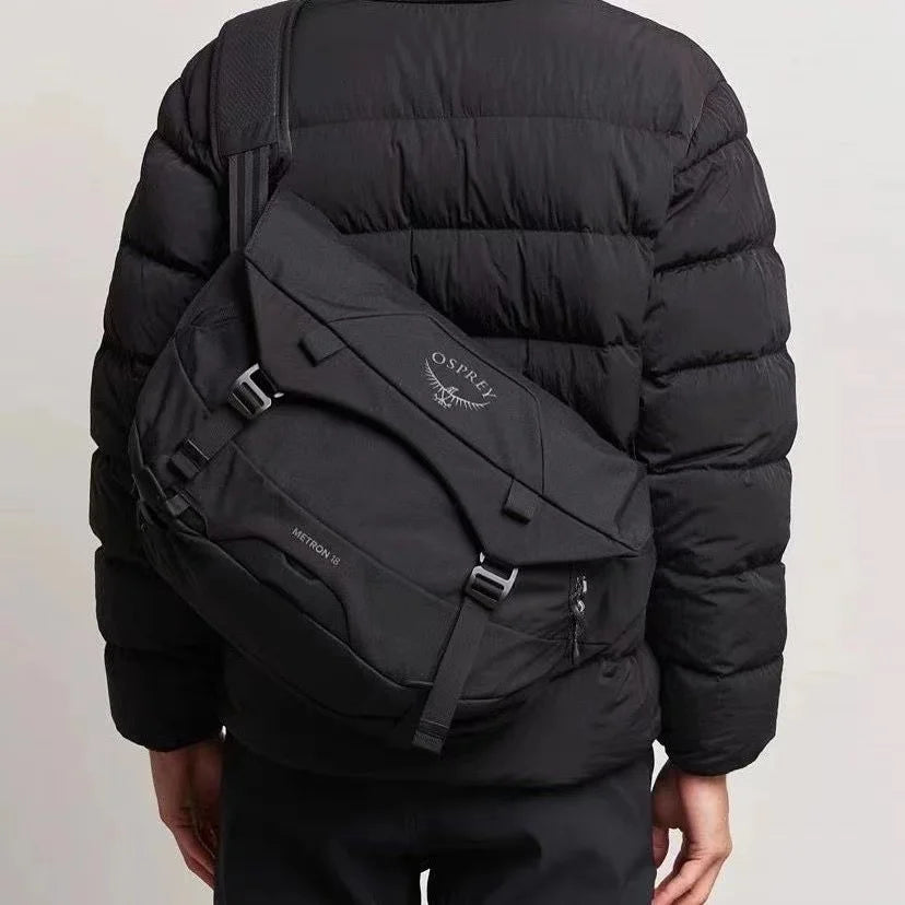 Zaino nero Osprey Metron 22L indossato su giacca imbottita, design urbano, resistente e spazioso, ideale per viaggi e uso quotidiano.