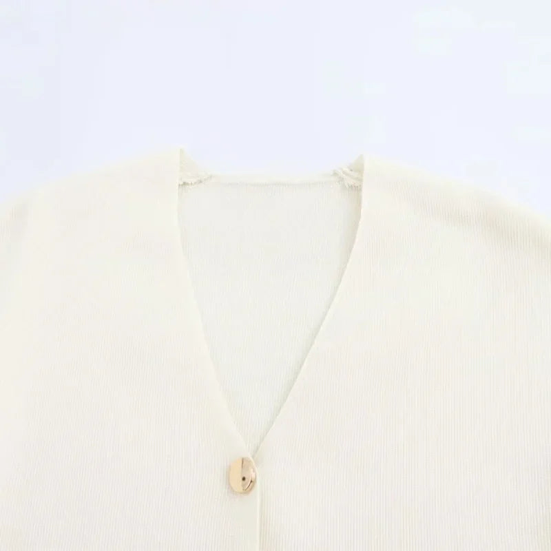 Cardigan beige in maglia a coste con scollo a V e bottone singolo. Elegante e versatile, ideale per look casual e formali.