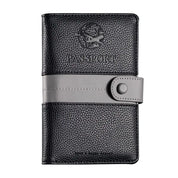 Custodia passaporto in pelle nera con chiusura a bottone grigia, design elegante e resistente, ideale per viaggiatori. Accessorio viaggio essenziale.