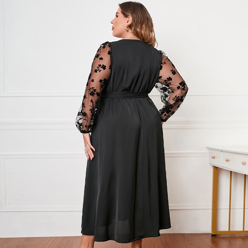 Abito nero elegante taglie forti, maniche lunghe in tulle con ricami floreali, donna di spalle, moda femminile, abbigliamento da sera.