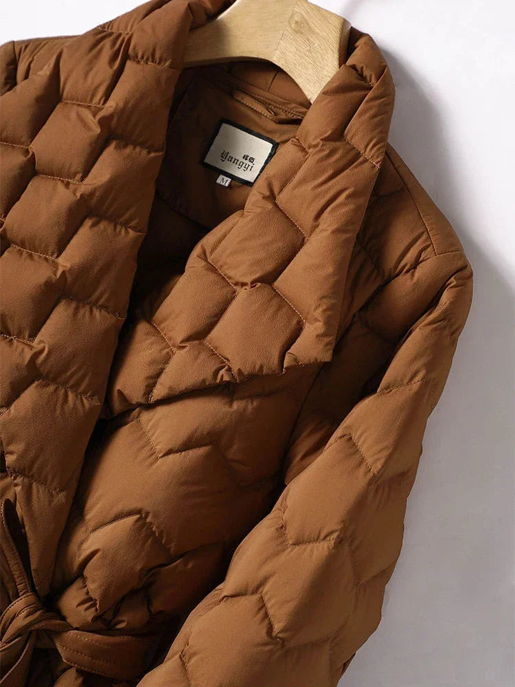 Giacca trapuntata marrone su appendiabiti, design elegante e moderno, ideale per l'inverno. Tessuto caldo e confortevole, perfetto per moda autunnale.