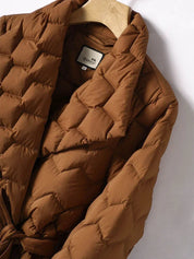Giacca trapuntata marrone su appendiabiti, design elegante e moderno, ideale per l'inverno. Tessuto caldo e confortevole, perfetto per moda autunnale.