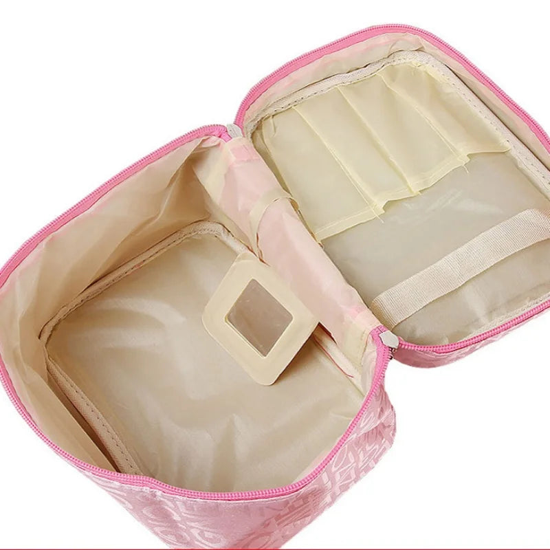 Astuccio cosmetico rosa aperto, con scomparti interni beige e specchietto. Ideale per organizzare trucchi e accessori da viaggio.