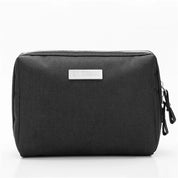 Astuccio organizer nero in tessuto resistente con doppia cerniera, ideale per viaggi e ufficio. Design compatto e funzionale per accessori.