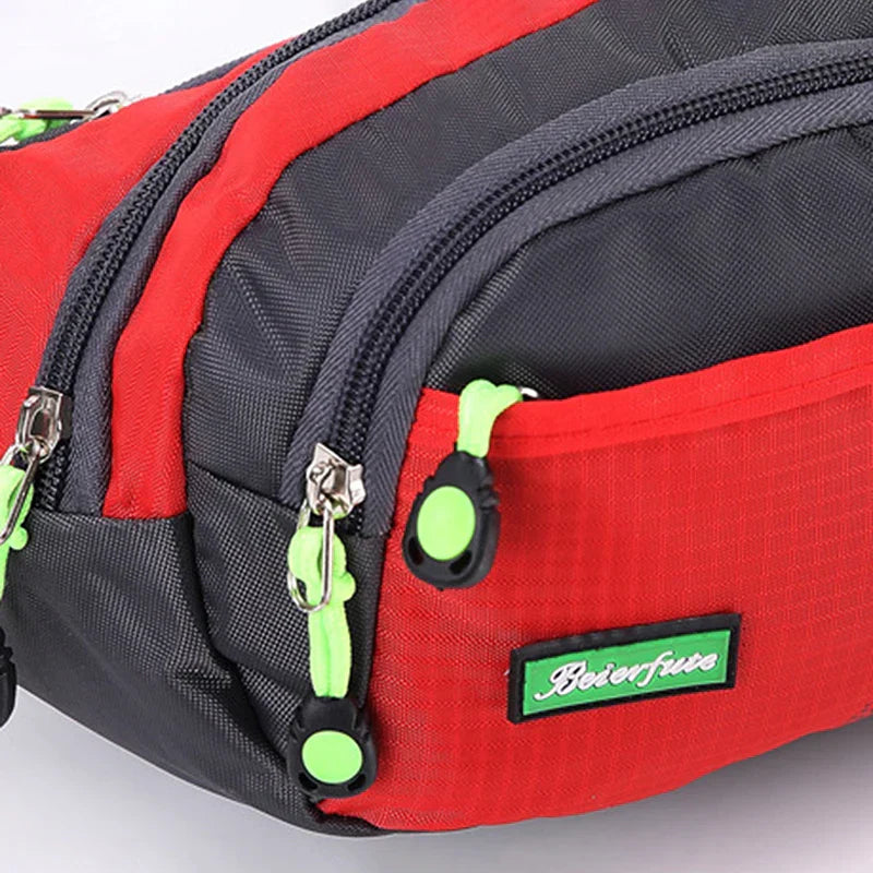 Marsupio sportivo rosso e grigio con cerniere verdi, ideale per escursioni e attività all'aperto. Design resistente e pratico.