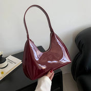 Borsa a spalla in pelle verniciata bordeaux, design elegante e moderno, perfetta per moda donna, accessorio chic per ogni occasione.