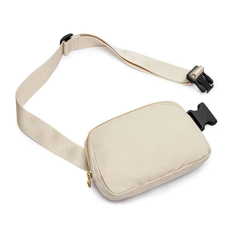 Marsupio beige in tessuto resistente con cerniera dorata e cintura regolabile. Accessorio moda unisex, pratico per viaggi e attività all'aperto.