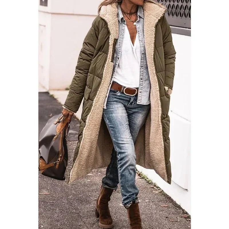 Cappotto lungo invernale verde con fodera in pelliccia sintetica, abbinato a jeans e stivali marroni. Look casual chic per donna.