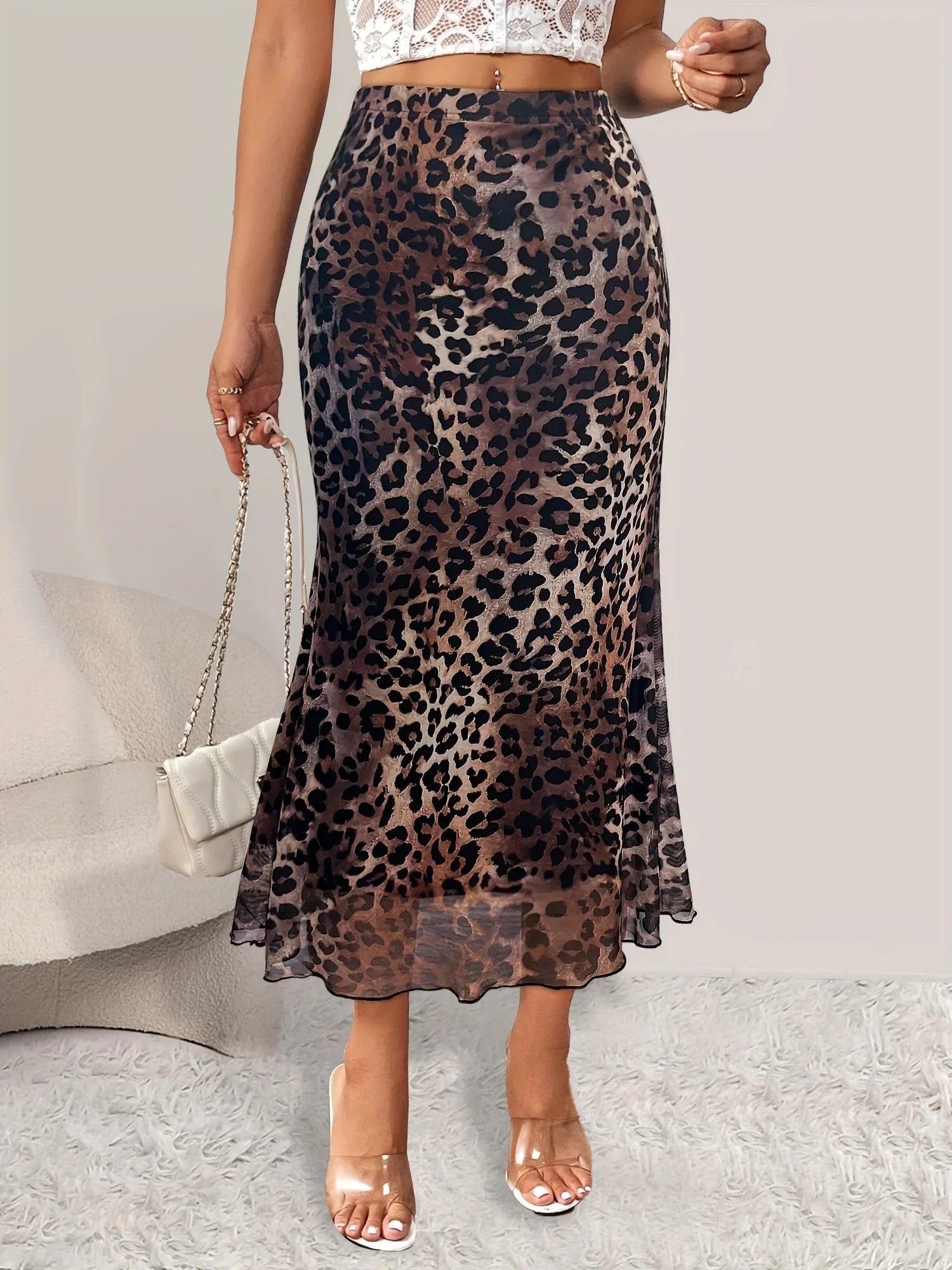 Gonna lunga leopardata, vita alta, tessuto leggero, indossata con top bianco in pizzo. Moda donna, stile elegante, tendenza abbigliamento 2023.