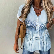 Camicia donna estiva con stampa floreale, maniche corte, scollo a V, abbinata a jeans. Stile casual, perfetta per look quotidiani.