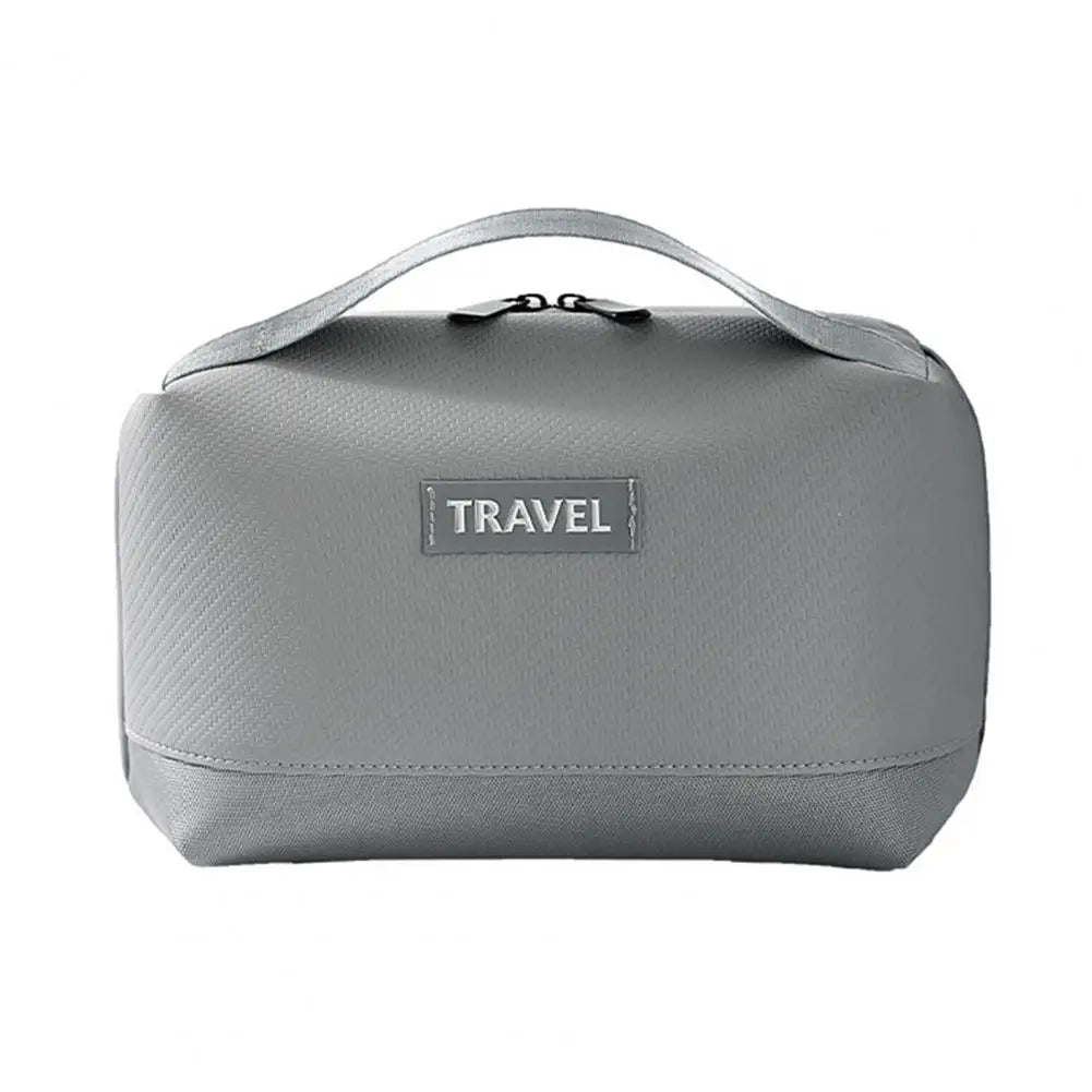 Borsa da viaggio grigia con manico, design compatto e chiusura a zip. Ideale per organizzare accessori e articoli da toeletta.
