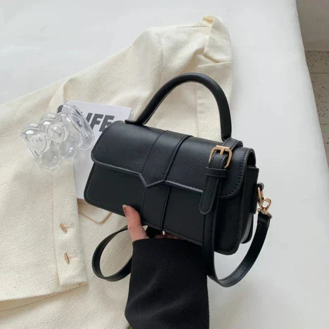 Borsa a tracolla nera elegante su sfondo bianco, design moderno con fibbia dorata. Accessorio moda donna, perfetto per ogni occasione.
