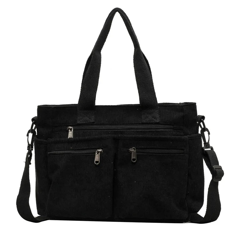 Borsa a tracolla nera in tessuto con manici, tasche frontali con cerniera e tracolla regolabile. Design elegante e funzionale per uso quotidiano.