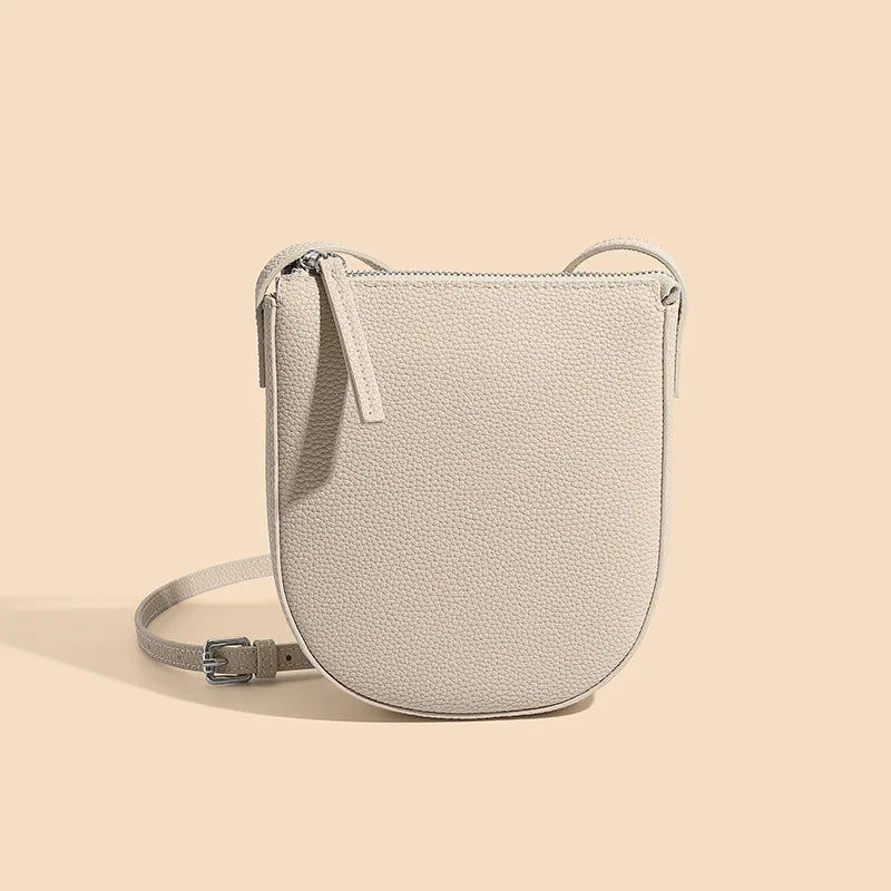 Borsa a tracolla beige in pelle, design minimalista, chiusura con zip, ideale per moda donna, accessorio elegante e versatile.