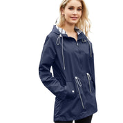 Giacca impermeabile donna blu con cappuccio, cerniera frontale e tasche, ideale per pioggia e outdoor. Stile casual, moda autunnale.