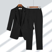 Completo donna nero elegante, giacca monopetto e pantaloni abbinati, abbigliamento formale, moda business, tessuto di alta qualità.