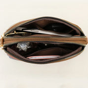 Borsa a tracolla in pelle marrone con cerniera aperta, mostra scomparti interni con smartphone, chiavi e accessori. Design elegante e funzionale.
