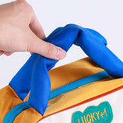 Mano che tiene una borsa termica colorata con manico blu, ideale per picnic e pranzo al sacco. Design moderno, perfetta per conservare cibi freschi.