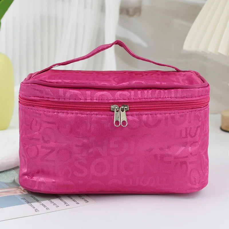 Borsa cosmetica rosa con cerniera, manico superiore, design elegante, ideale per trucco e accessori da viaggio. Perfetta per organizzazione beauty.