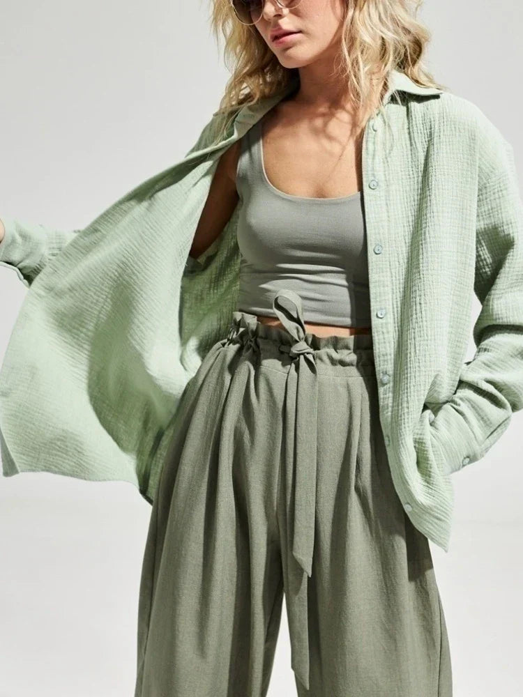 Donna con camicia verde chiaro in cotone, top corto e pantaloni a vita alta. Moda casual estiva, abbigliamento femminile trendy.