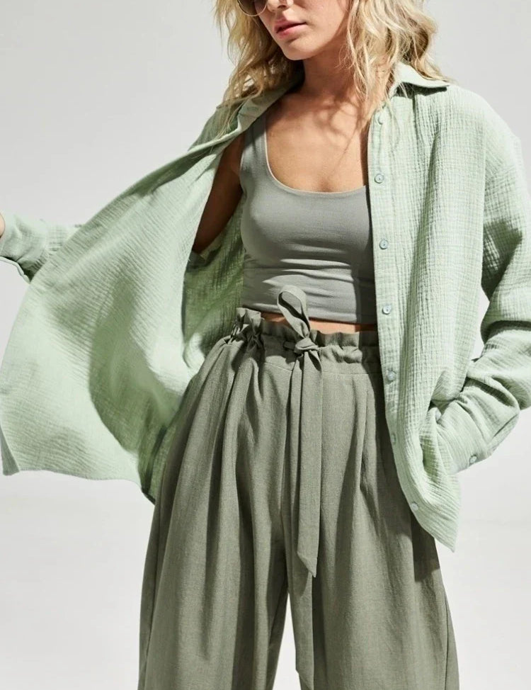 Donna con camicia verde chiaro in cotone, top corto e pantaloni a vita alta. Moda casual estiva, abbigliamento femminile trendy.