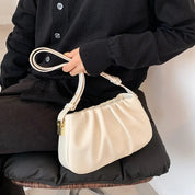 Borsa a spalla bianca elegante con manico intrecciato, indossata da una persona in abbigliamento nero. Design moderno, ideale per moda femminile.