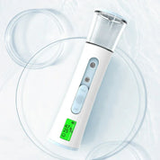 Spruzzatore viso portatile bianco con display LED, doppio ugello, serbatoio trasparente, su sfondo acqua. Idratante viso, cura della pelle.