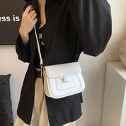 Borsa a tracolla bianca elegante indossata su camicia nera, design moderno, perfetta per moda casual e uscite quotidiane. Accessorio femminile trendy.