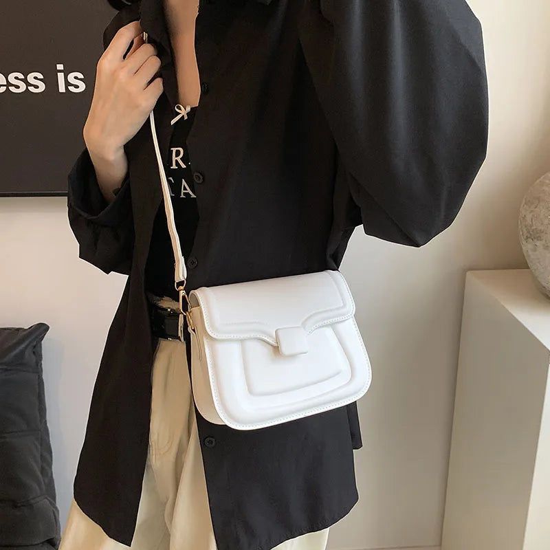 Borsa a tracolla bianca elegante indossata su camicia nera, design moderno, perfetta per moda casual e uscite quotidiane. Accessorio femminile trendy.