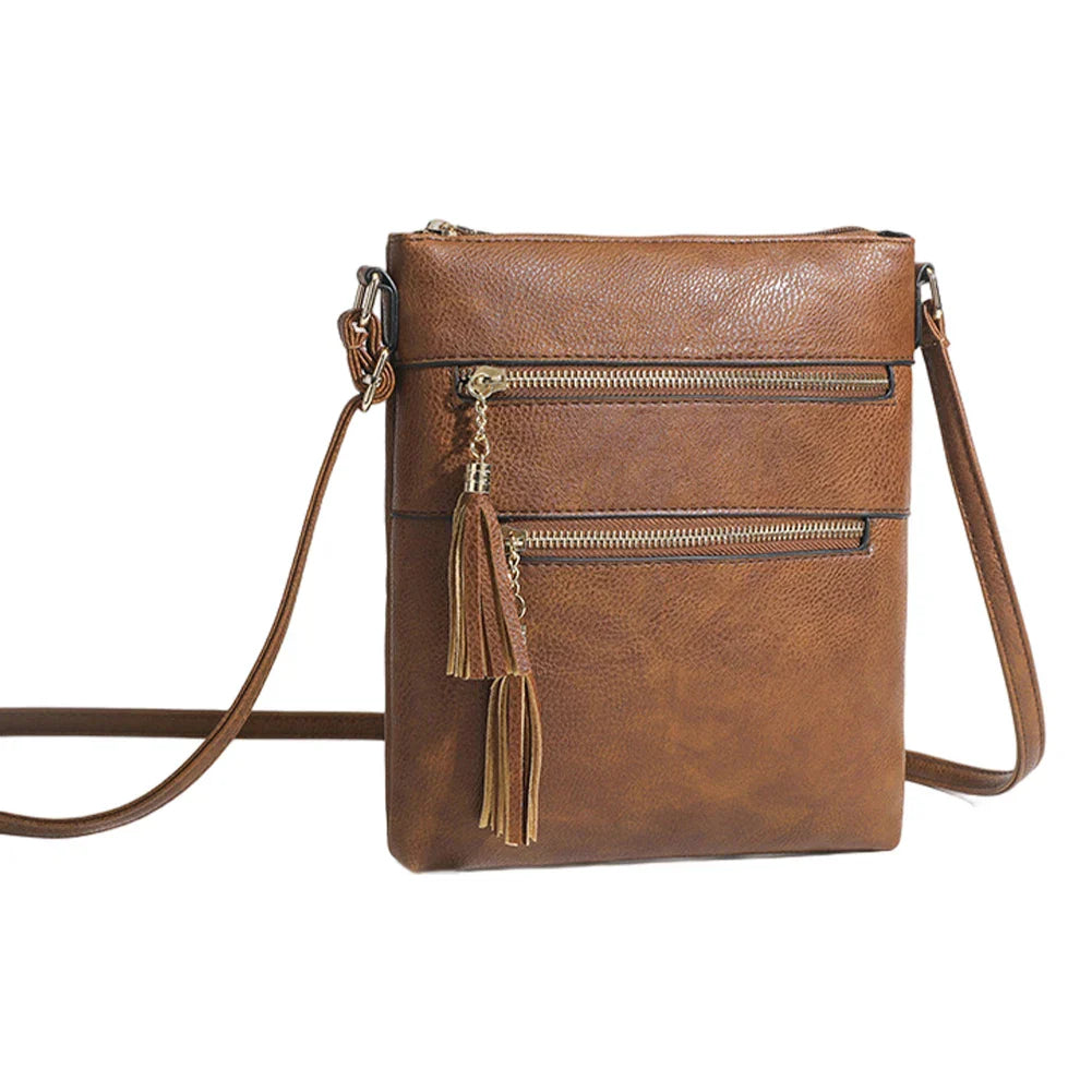 Borsa a tracolla in pelle marrone con cerniere dorate e nappine decorative. Design elegante e pratico, ideale per moda donna e accessori.