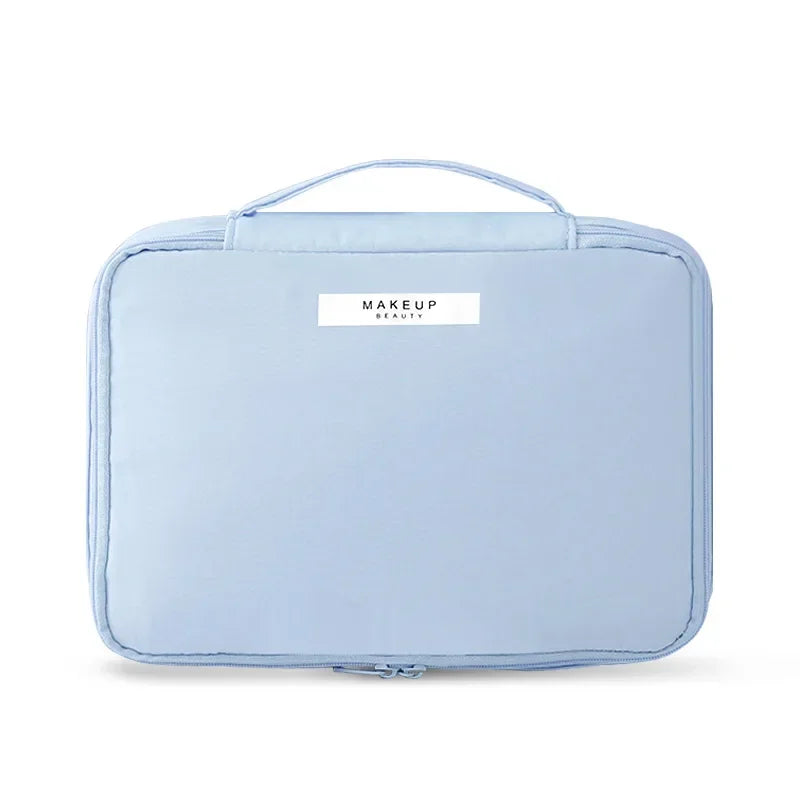 Custodia trucco azzurra con manico, design compatto e etichetta "Makeup Beauty". Ideale per organizzare cosmetici in viaggio.