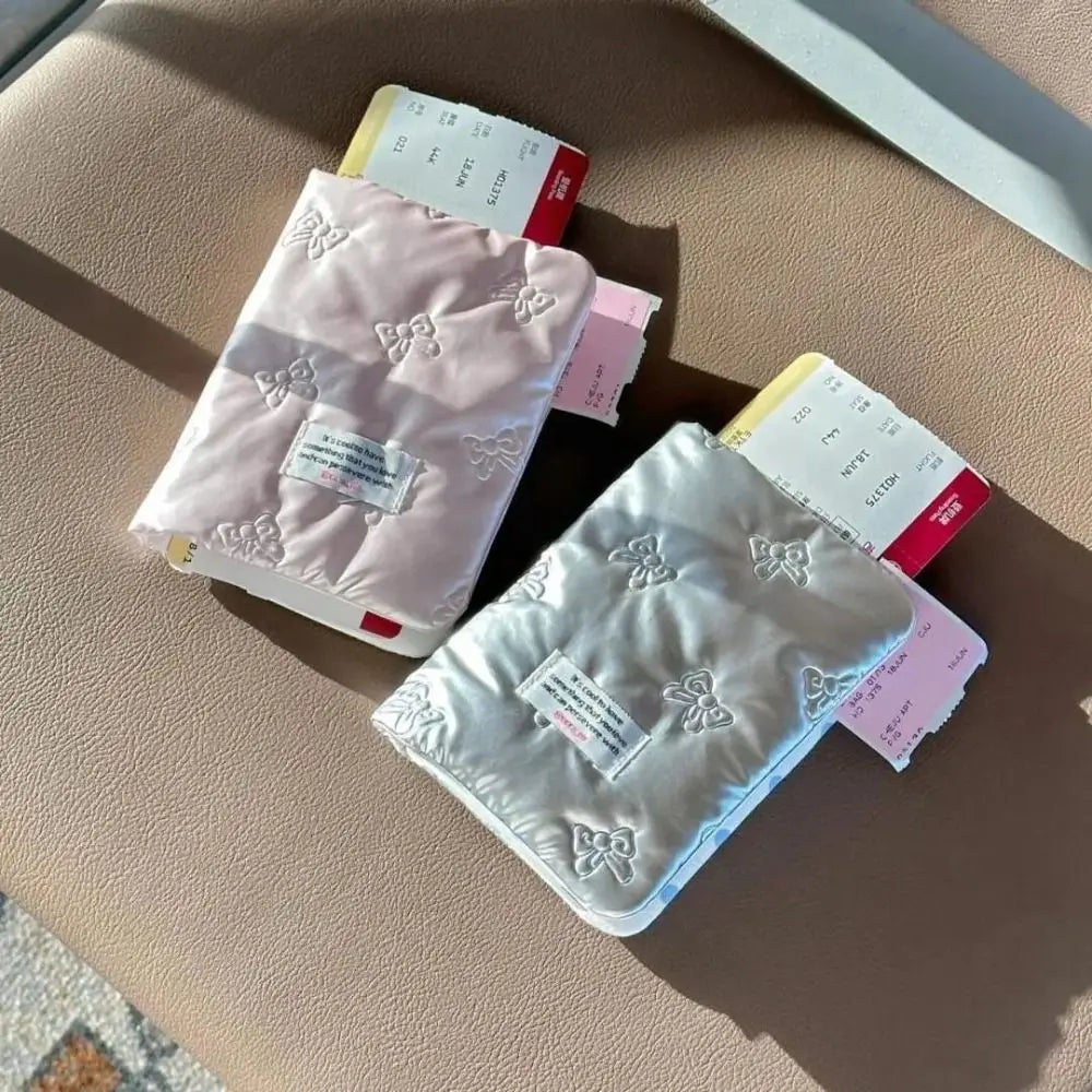 Due porta passaporti imbottiti, uno rosa e uno bianco, con biglietti aerei su sedile. Accessori da viaggio eleganti e funzionali.