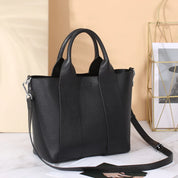Borsa a mano in pelle nera con tracolla regolabile, design elegante e moderno, perfetta per l'uso quotidiano e occasioni speciali.