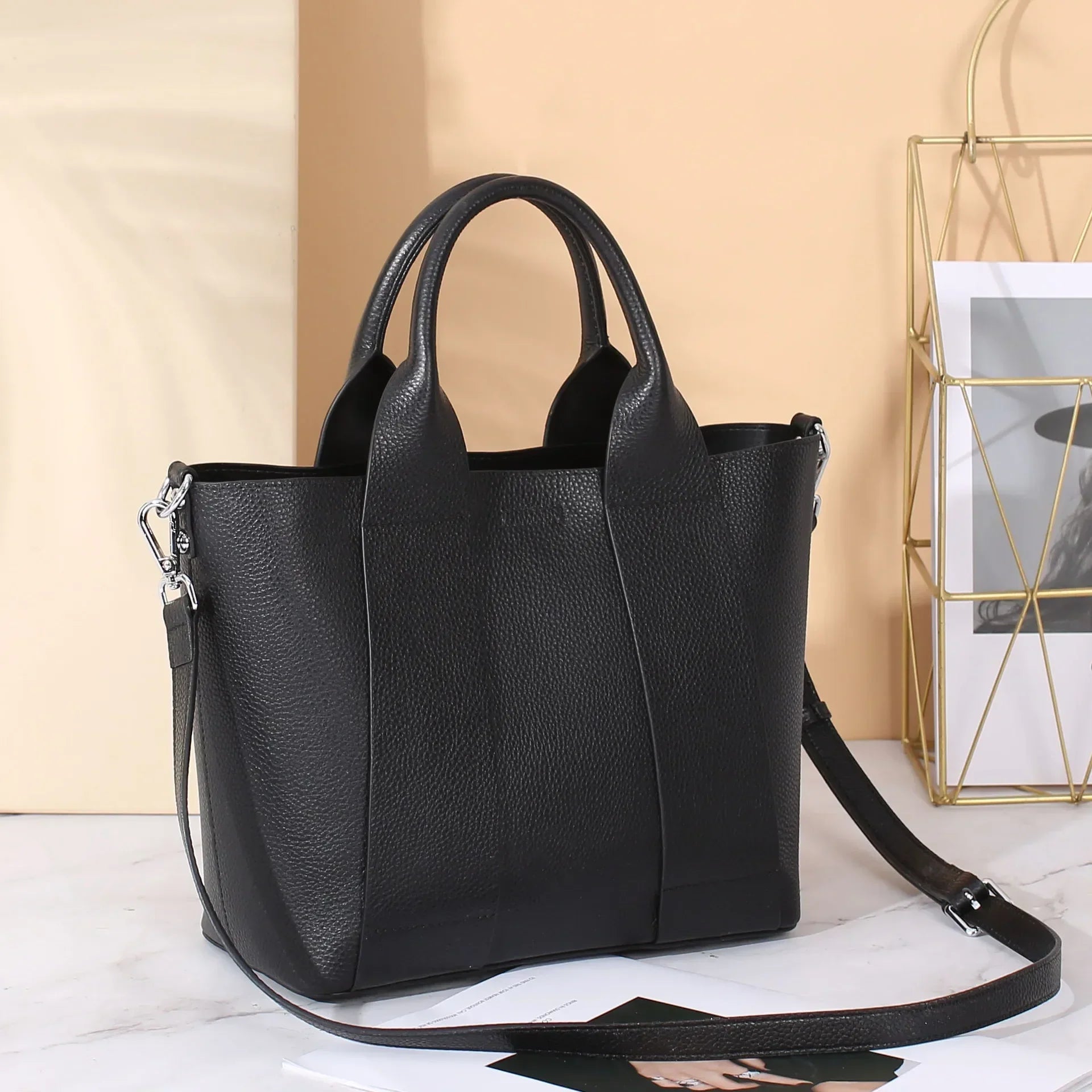 Borsa a mano in pelle nera con tracolla regolabile, design elegante e moderno, perfetta per l'uso quotidiano e occasioni speciali.